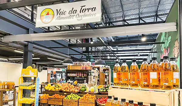 Seção de alimentos orgânicos no mercado 'Veio da Terra', com variedades de frutas, sucos naturais e produtos saudáveis na loja de produtos orgânicos.