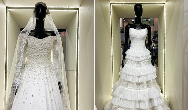 Duas impressionantes opções de vestidos de noiva em vitrine, um com mangas longas e detalhes em pérolas, e outro com babados e alças finas. Imagens de um dos eventos sobre casamento em São Paulo.