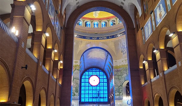 Imagem do interior do Santuário de Fátima, com arquitetura impressionante, iluminação acolhedora e decoração religiosa, destacando-se por sua beleza e espiritualidade.