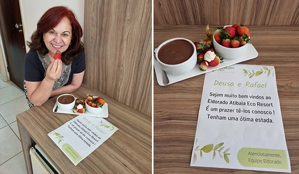 Deusa Rodrigues, segurando um morango, sentado ao lado de uma mesa com uma sobremesa de chocolate, morangos e uma mensagem de boas-vindas no resort Atibaia Eco Resort.