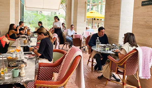 Foto de um angulo diferente do Restaurante do Hotel Rosewood, onde aparece diveras mesas com clientes.