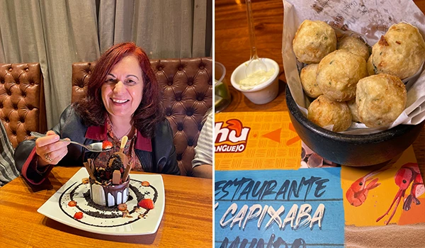 Deusa Rodrigues saboreando uma sobremesa de chocolate em um restaurante capixaba, acompanhada de um prato de petiscos da culinária local.
