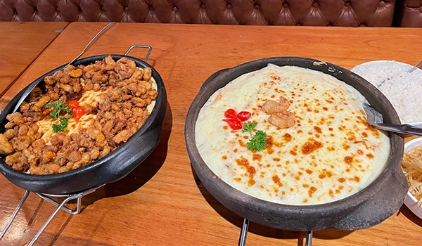 Prato delicioso com camarão crocante e um acompanhamento de moqueca, ideal para amantes de comida brasileira. Imagem faz parte do Restaurante Ilha do Caranguejo em Vitória.