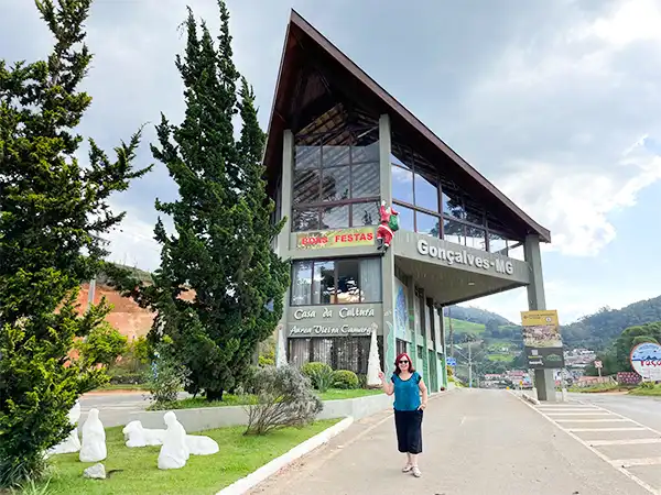 Deua Rodrigues, vista da Casa da Cultura em Gonçalves-MG, destacando a arquitetura moderna e o ambiente ao ar livre.