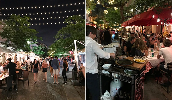 Ambiente noturno vibrante de um restaurante ao ar livre, com mesas ocupadas e luzes penduradas, criando uma atmosfera acolhedora.