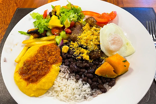 Prato típico com arroz, feijão preto, carne com farofa, ovo, legumes polenta e salada. Uma deliciosa refeição brasileira completa e nutritiva.