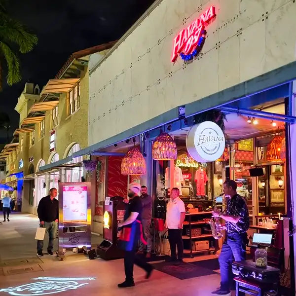 Visão noturna do restaurante Havana com iluminação vibrante e músicos tocando. Ambiente animado e acolhedor, ideal para desfrutar uma noite especial.