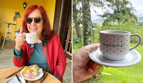 Deusa Rodrigues segurando xícara de café com prato de alimentos. Em cenário ao ar livre com vista para a natureza, promovendo gratidão.