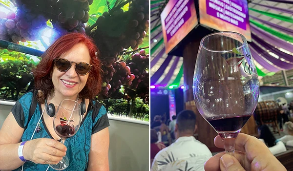 Deusa Rodrigues segurando taça de vinho em ambiente festivo com uvas ao fundo, muito colorido e alegre, na típica Festa da Uva de Jundiaí.