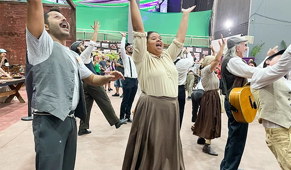 Grupo de pessoas dançando e cantando com alegria em uma apresentação ao vivo, celebrando a cultura e a arte na típica Festa da Uva de Jundiaí.