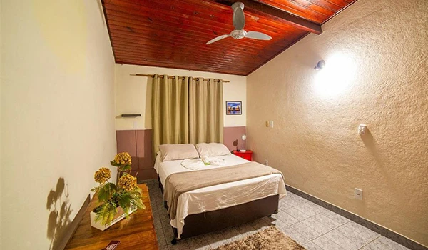 Quarto aconchegante com cama de casal, decoração simples e iluminação suave. Ideal para relaxar e aproveitar uma boa estadia.