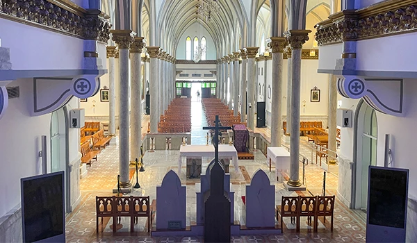Igreja interna com bancos organizados e um altar central. Os pilares altos e a iluminação tornam o ambiente acolhedor e espiritual. Dicas sobre o que fazer em Franca.