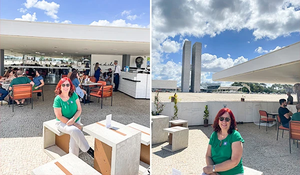 Deusa Rodrigues sentada na parte externa ao ar livre, da Casa de Chá SENAC - DF com vista para um edifício moderno sob céu azul com nuvens.