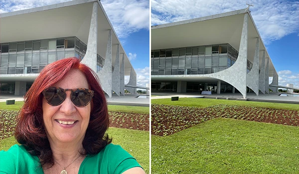 Selfie Deusa Rodrigues em frente a um edifício moderno, com estrutura arquitetônica arrojada e jardim bem cuidado ao redor.