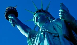 Estátua da Liberdade iluminada em azul, representando a liberdade e a irmandade nos Estados Unidos.
