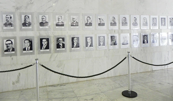 Galeria de retratos em preto e branco de personalidades históricas, exibindo importantes figuras do passado em um ambiente iluminado e organizado. Dicas sobre a visita ao Palácio do Planalto.