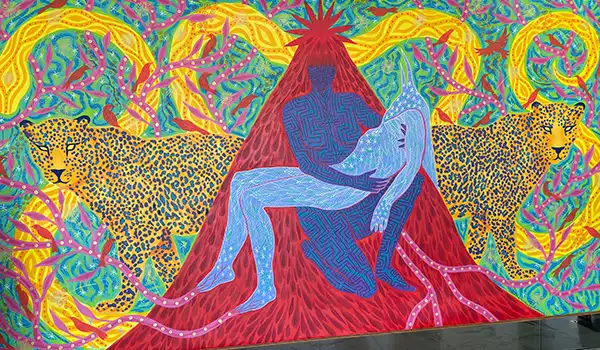 Pintura vibrante com figuras humanas e leopardos em um grande mural colorido, representando amor e conexão com a natureza.