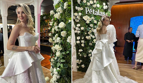 Duas modelos desfilando com vestidos brancos de festa em um evento floral com decoração de rosas brancas e fundo com o nome 'Petalas' em destaque. Evento Casar.com para Noivas.