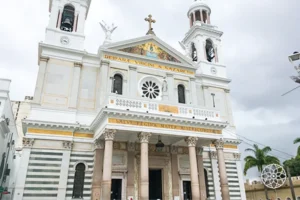 Imagem da fachada de uma igreja católica com arquitetura clássica, colunas, torres e cruz no topo, localizada na cidade de Natal, Rio Grande do Norte, Brasil.