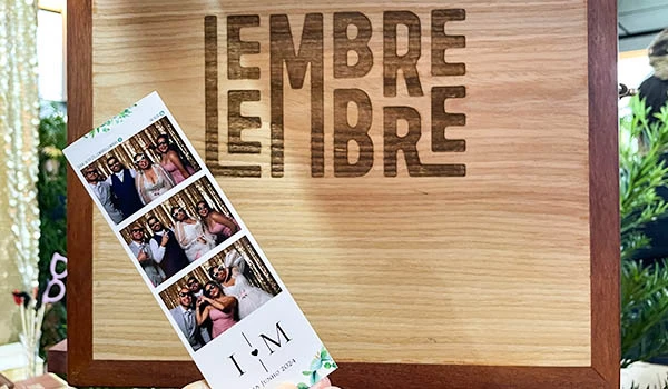 Evento Casar.com no estand da Lembre Lembre,, com foto de grupo e decoração em madeira, destacando fotos impressas e tema de reunião.