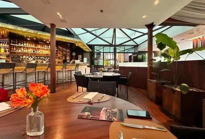 Imagem de um elegante restaurante moderno com um bar bem iluminado e decoração sofisticada, oferecendo uma experiência gastronômica de alta qualidade.