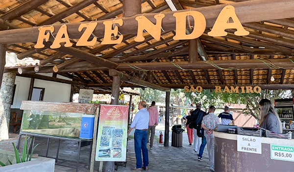 Entrada do restaurante Faze N D'A em São Ramiro com estrutura rústica de madeira e pessoas aguardando na fila, com destaque para a placa de entrada