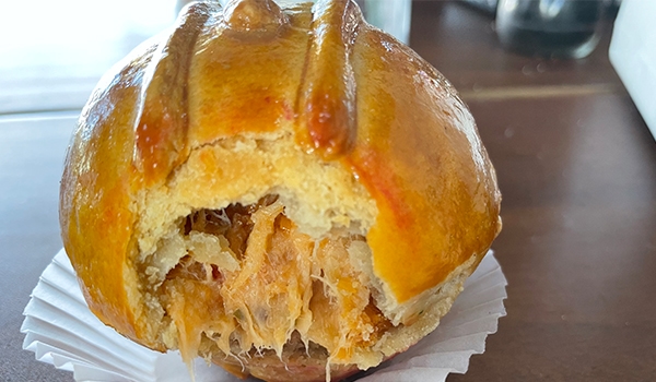 Imagem de uma empada recém-assada com massa dourada e recheio de frango, ideal para lanche. Rotas Gastronômicas do interior de SP.