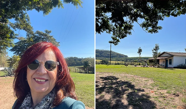 Deusa Rodrigues em um ambiente externo com árvores, céu azul e uma casa ao fundo.