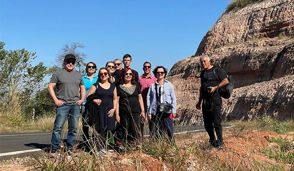 Grupo do Press Trip de Rotas Gastronômicas do Interior de São Paulo, em julho de 2025, perto de uma formação rochosa, com céu azul ao fundo em Marília.