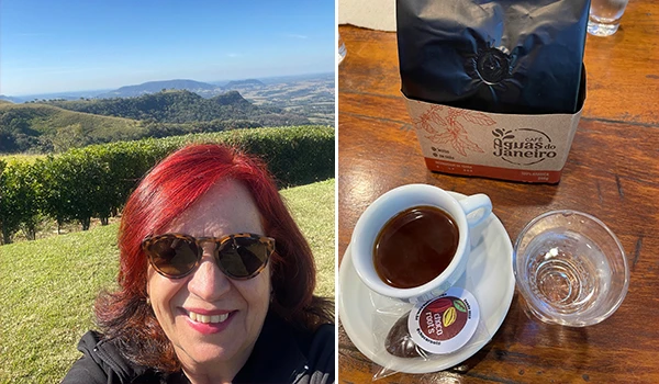 Imagem de Deusa Rodrigues usando óculos escuros, ao ar livre com vista para a região da Cuesta, ao lado de uma mesa com café, água e embalagem.