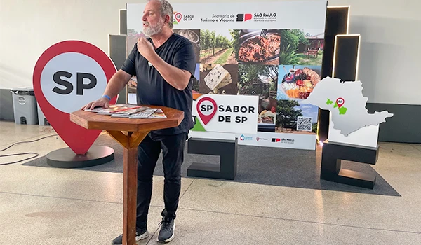Diretor do Mundo Mesa, no evento sobre sabores de São Paulo, com foco na cultura e gastronomia local, em ambiente interno com painel sobre o tema.