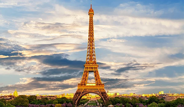 Vista Prévia Da Torre Eiffel Em Paris, França Com Céu Nublado E Luz Do Sol Nacente, Destacando-Se Como Ponto Turístico Famoso.