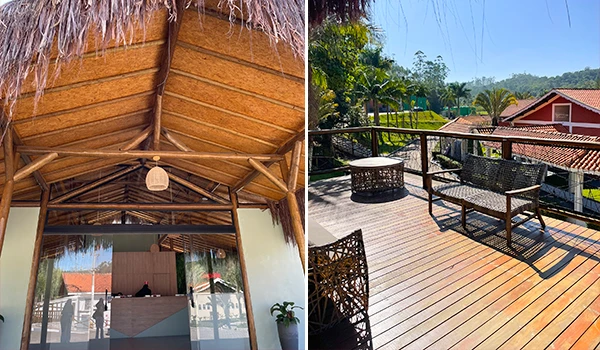 Imagem de um espaço outdoor em uma casa, incluindo varanda com móveis de fibra sintética, cercada por uma paisagem tropical com árvores e céu claro.