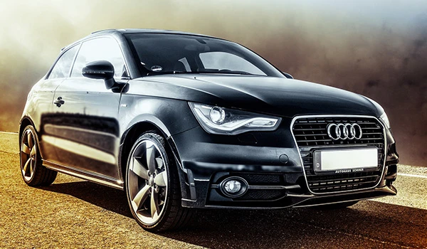 Audi hatchback preto em estrada com fundo desfocado, destaque para o design moderno e rodas esportivas, ideal para quem busca estilo e performance.