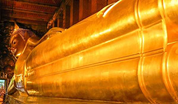 Imagem da gigantesca estátua de Buda dourada, símbolo de paz e espiritualidade, localizada em um templo tradicional na viagem pela Ásia.