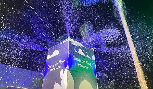 Chuva de neve em uma experiência ao ar livre com iluminação colorida, na Parada de Natal de Holambra.