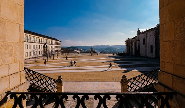 Atrações de Coimbra, com suas áreas abertas e arquitetura histórica sob céu claro, ideal para turismo e passeios.