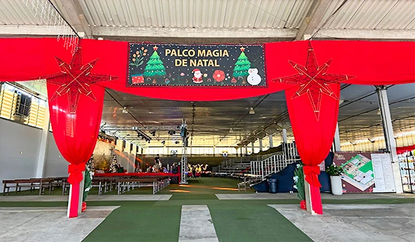 Decoração natalina no Palco Magia de Natal, com grandes estrelas vermelhas, entradas decoradas, e ambiente festivo para shows e eventos natalinos.