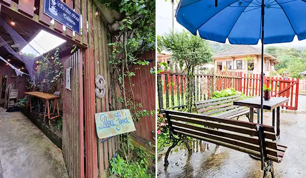 Espaço ao ar livre em um restaurante ou café com mesas, cadeiras, guarda-chuvas azuis e vegetação ao redor, ideal para refeições ao ar livre em dias chuvosos.