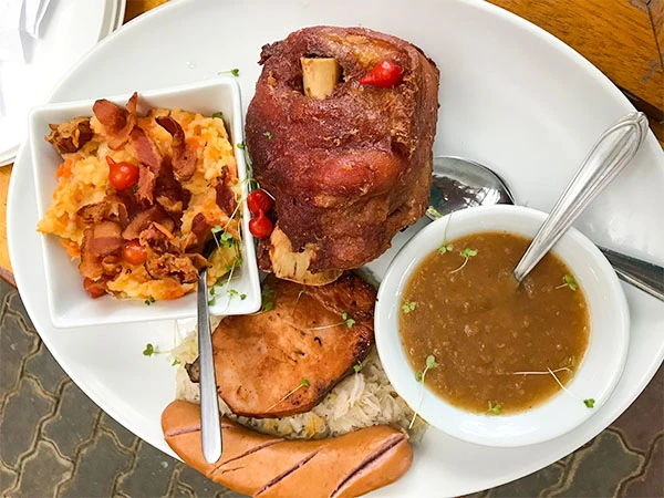 Prato típico brasileiro com carne de olla, feijão tropeiro, arroz, salgado com salsicha e acompanhamentos, ideal para quem busca comida tradicional.