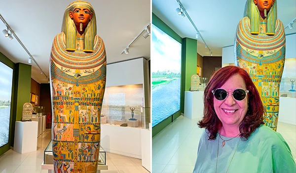 Deusa Rodrigues ao lado de uma estátua de faraó egípcio em um museu, com iluminação moderna e detalhes históricos na decoração. Museu Egípcio e Rosacruz em Curitiba.