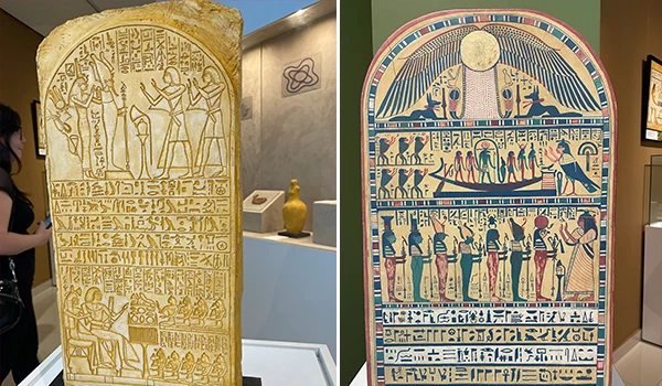 Reproduções de hieróglifos e cenas do Antigo Egito em urnas funerárias exibidas em um museu, destacando aspectos históricos e culturais.
