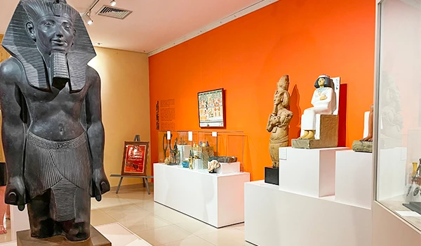Exposição de arte egípcia em museu, com estátua de faraó e esculturas de deuses. Museu Egípcio e Rosacruz em Curitiba.