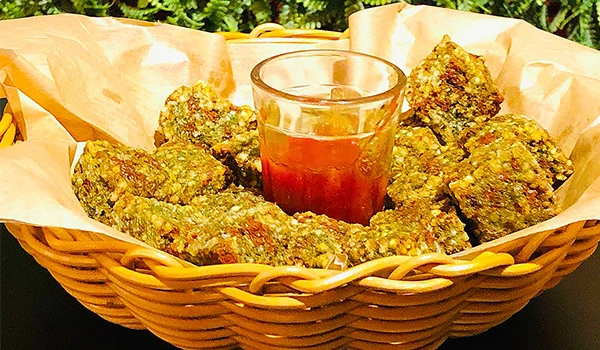 Cesta com dadinhos entre bebida vermelha, um dos pratos de restaurante da Ilhabela.