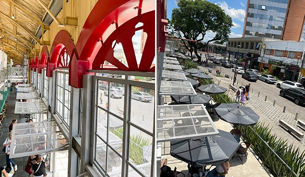 Imagem mostra a fachada de uma cafeteria moderna com janelas grandes e decoração em vermelho, ao lado de uma rua movimentada com cadeiras e guarda-sóis ao ar livre. Onde comer em Curitiba.