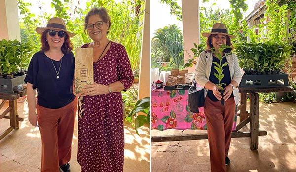 Foto de Deusa Rodrigues com uma muda de pé de café e a proprietária da Fazenda Água Limpa segurando um pacote de café.