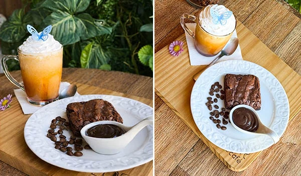 Duas imagens lado a lado mostrando café gelado em copo com espuma, servido com fatia de bolo de chocolate e potinho de molho de chocolate, em mesa de madeira, com detalhes de grãos de café e decoração floral. Festival do Café de Mococa.