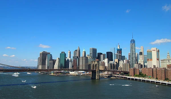 Vista panorâmica do skyline de Manhattan, em Nova York, com arranha-céus altos ao fundo e o rio Hudson em primeiro plano, mostrando a costa e pontes ao redor. Cidades dos Estados Unidos na Copa.