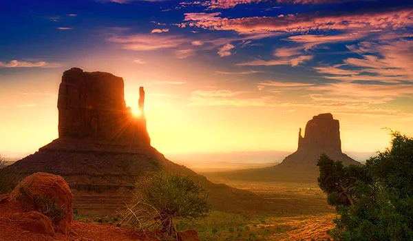 Foto de Monument Valley um dos pontos turísticos dos Estados Unidos em destaque no pôr do sol no parque.