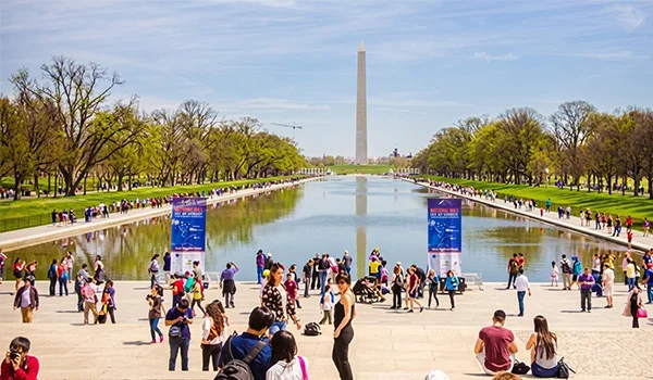 Foto da esplanada National Mall com muita gente passeando e ao fundo o famoso Obelisco em Washington.